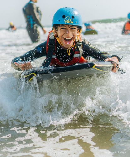 Smiling child on a surf board in the sea.