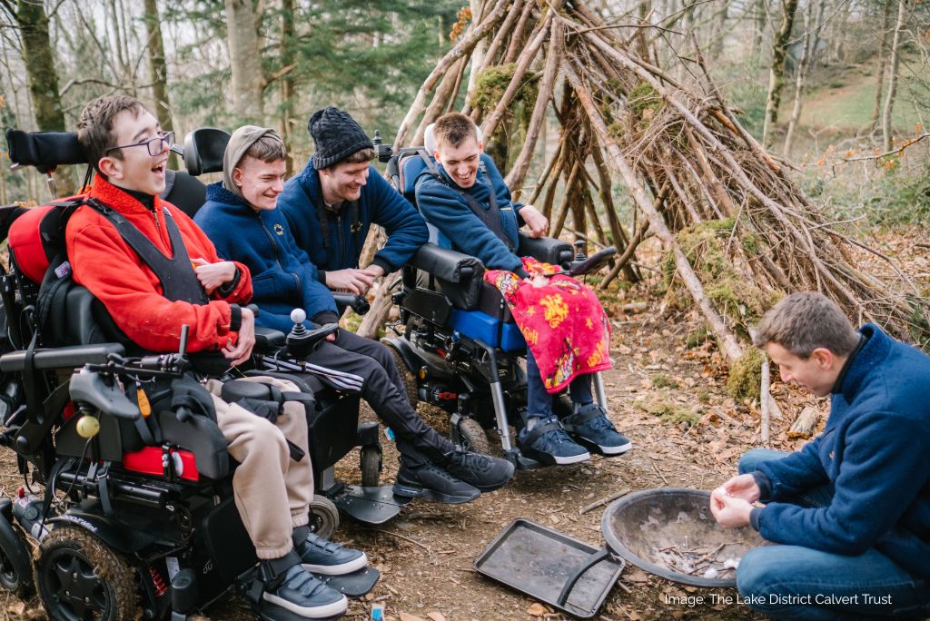 Young people in wheel chairs in a forest.