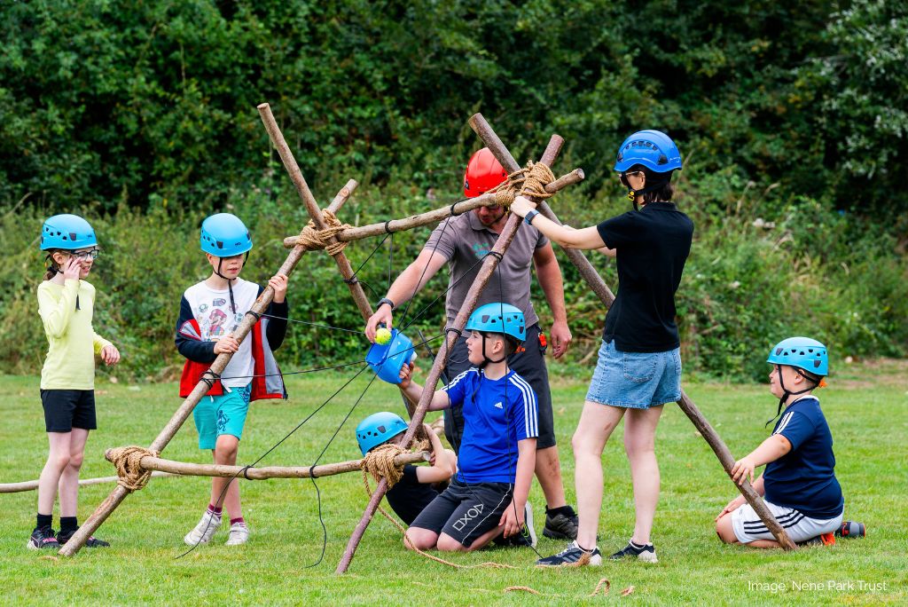 Image of children building a structure from branches.